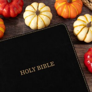 Christian holy bible book with pumpkin fruit on wooden background