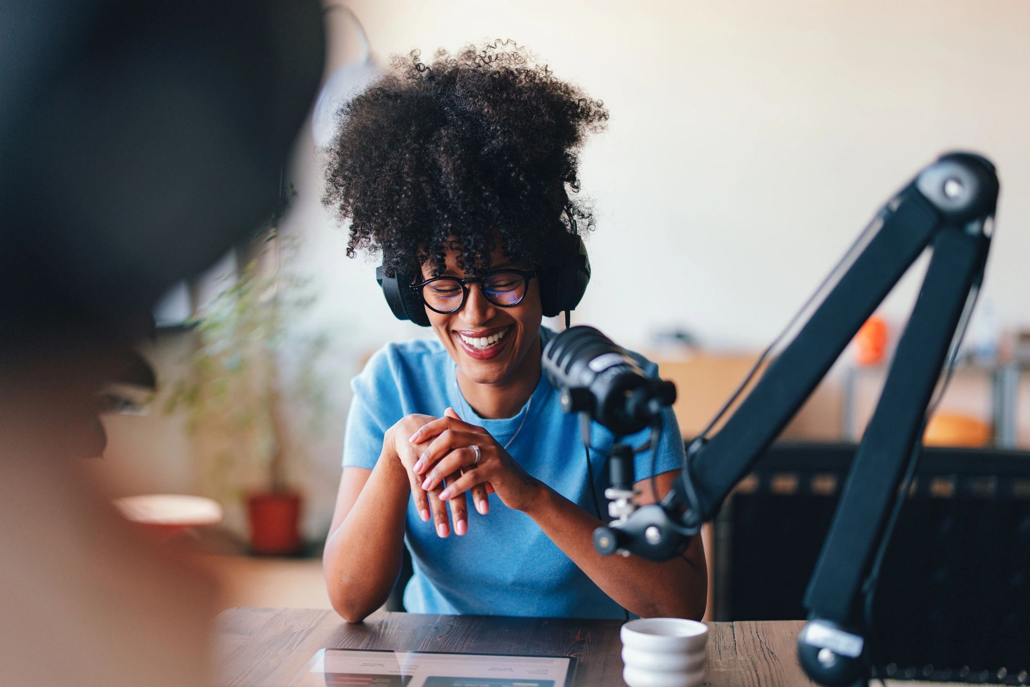Woman speaking into a microphone during a radio-style interview